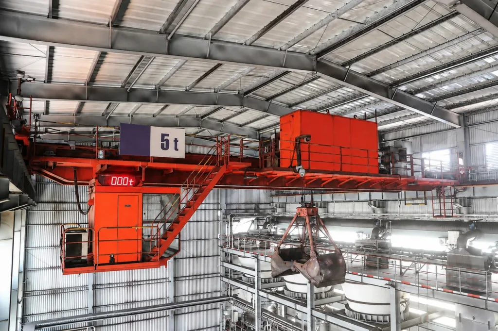 Installed overhead grab crane above process hoppers in a steel plant