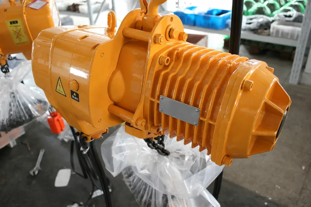 Close factory view of an electric chain hoist motor, cooling fins, housing and upper suspension