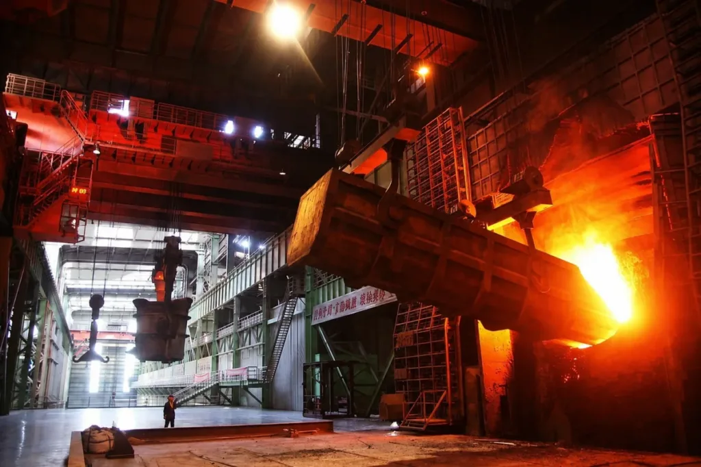 Charging crane positioning a suspended charging box at a furnace