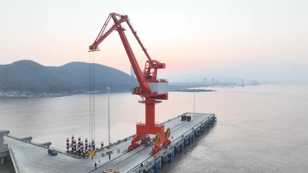 Portal harbour crane installed on a quay beside navigable water