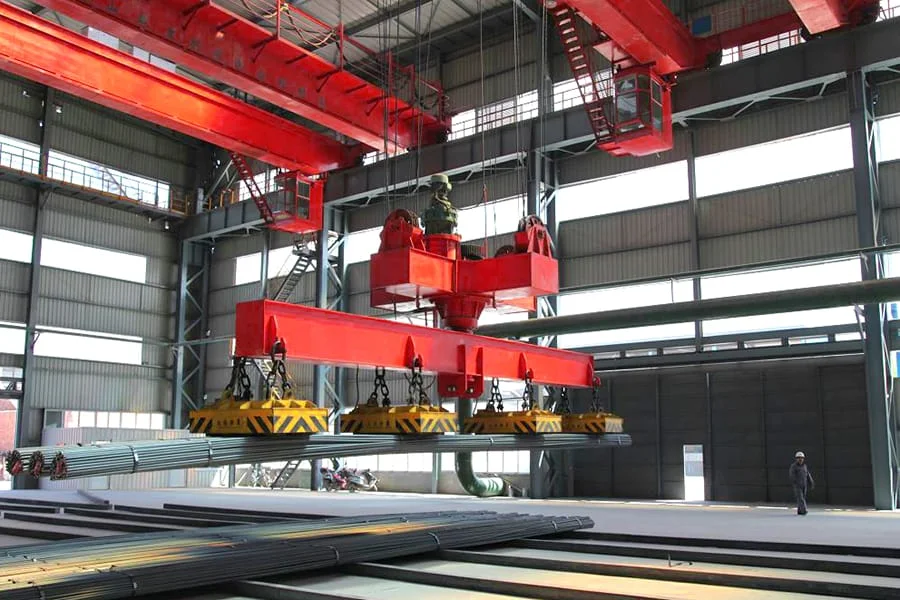 A rotating magnet beam lifting a bundle of long steel bars in a mill