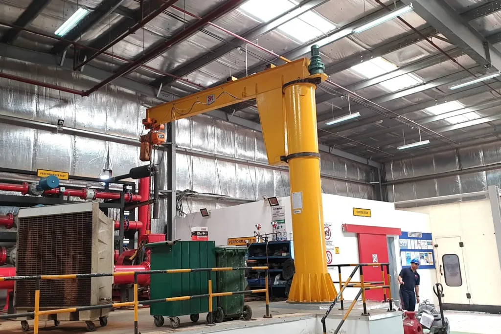 Freestanding pillar-mounted jib crane with mast, rotating boom, trolley and hoist
