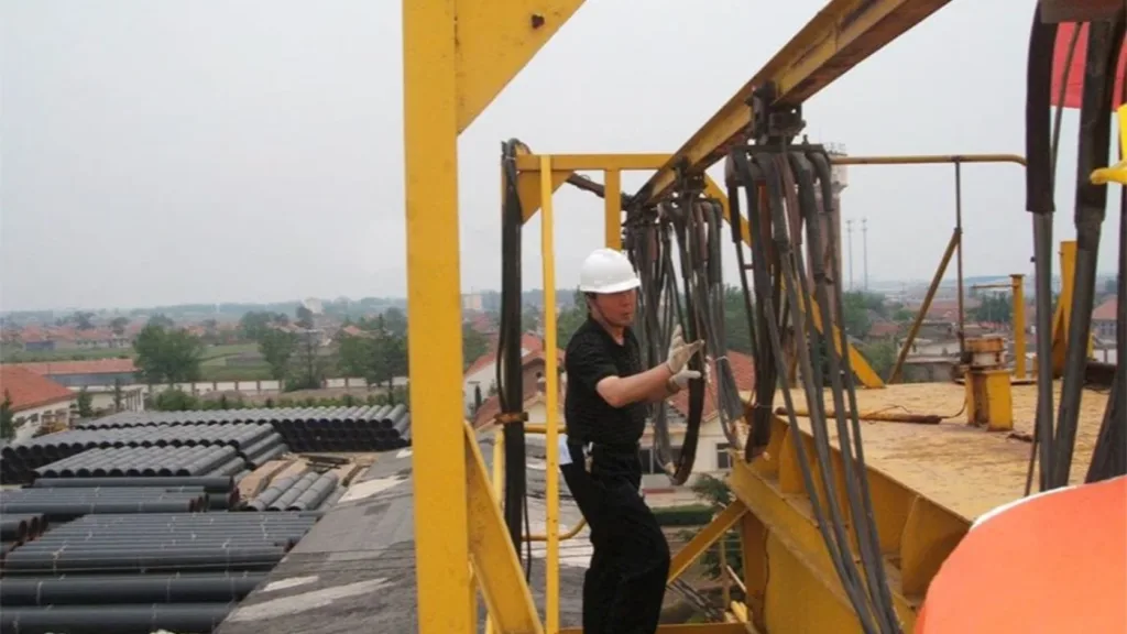 Technician inspecting outdoor crane cable carriers