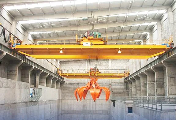 Grab crane suspended above a deep bulk-material bunker