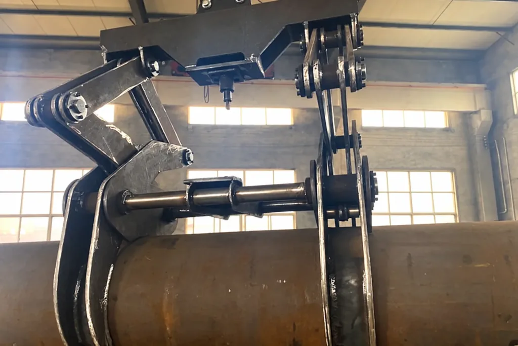 Close view of linked pipe tong jaws surrounding a cylindrical steel pipe