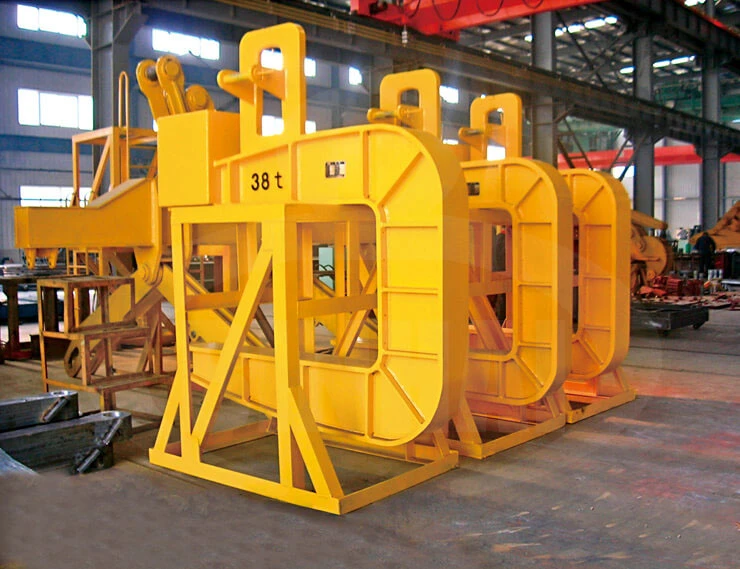 Yellow counterweighted C-hooks with open lower supporting arms resting on workshop storage stands; markings belong to the photographed equipment