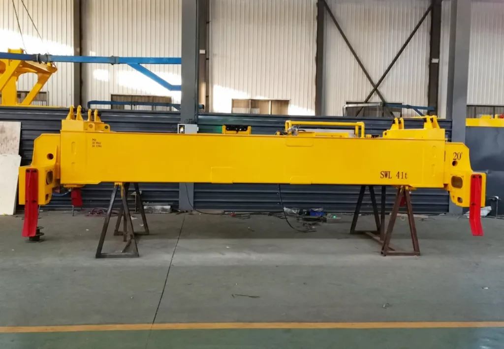 Telescopic single-container spreader with end guide flippers on workshop stands