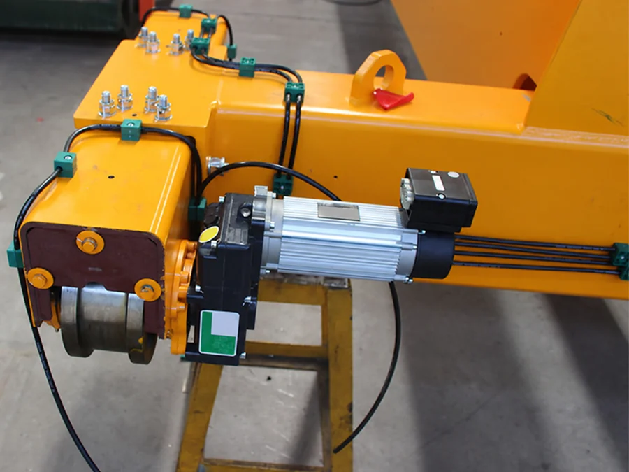 Brake gearmotor installed on a yellow crane end carriage, showing its motor and gearbox connection