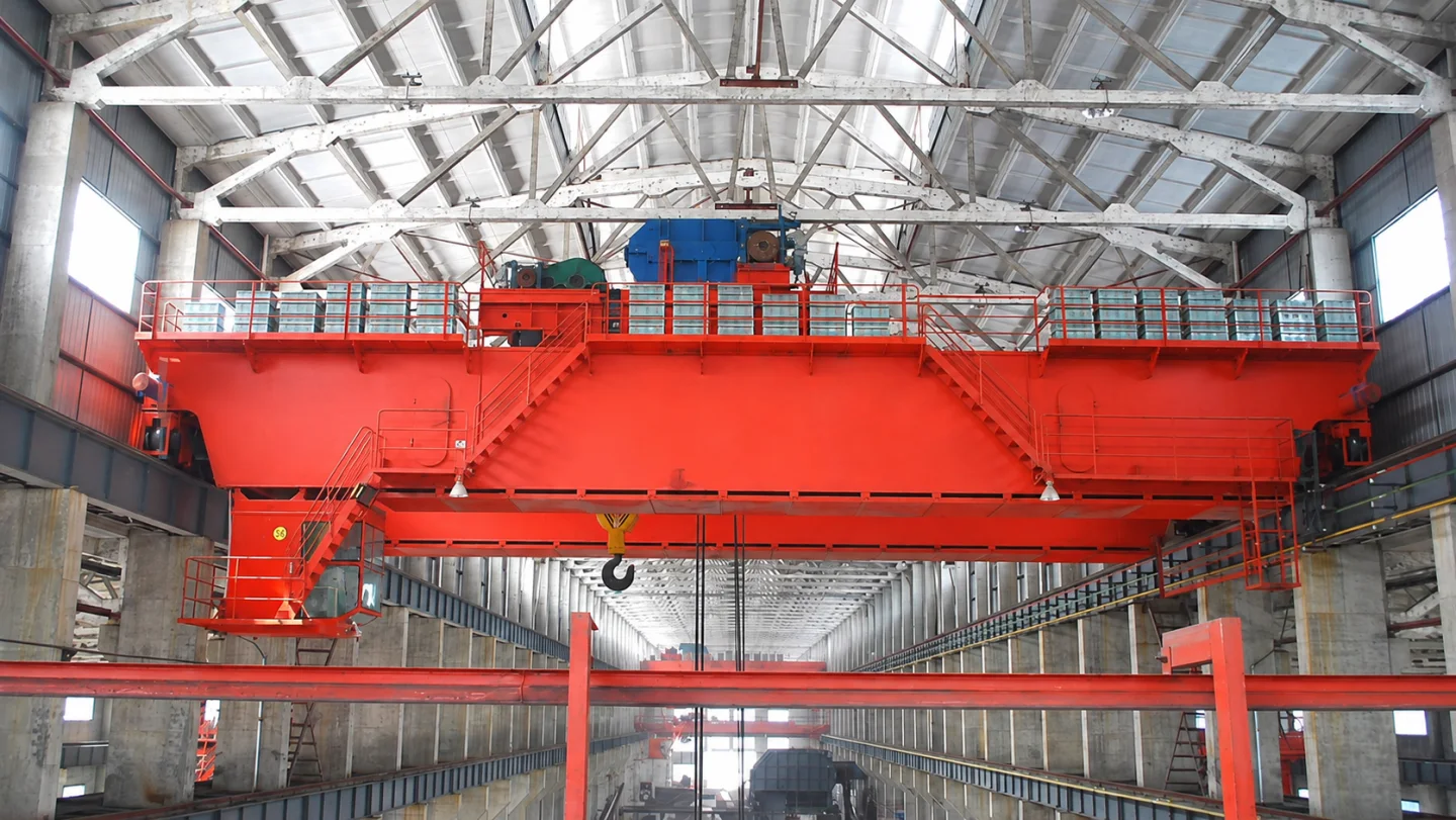 Double-girder crane with an open trolley, access platforms and suspended hook in an industrial hall