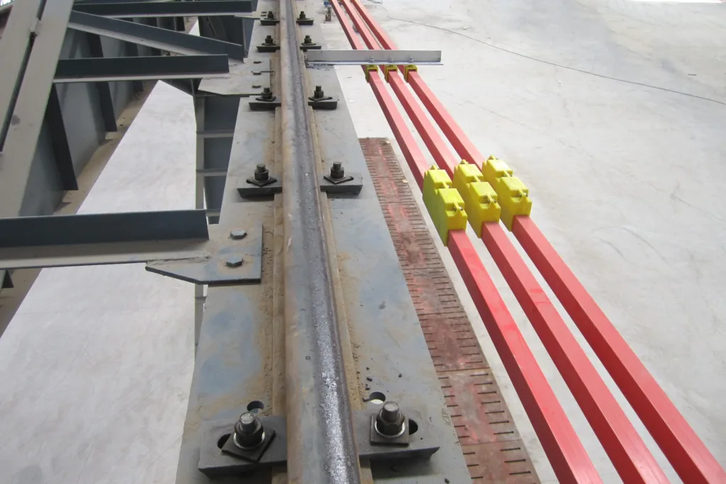 Individually insulated conductor bars mounted beside the steel running rail