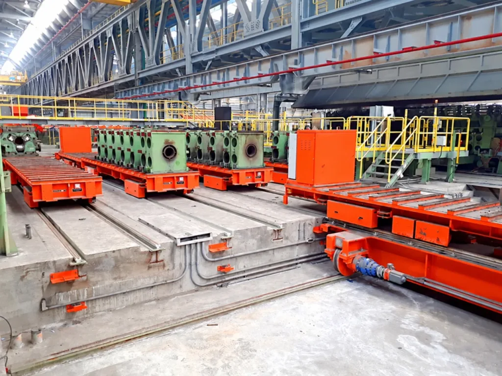 Mill-stand carriers on parallel rails beside a perpendicular ferry transfer vehicle