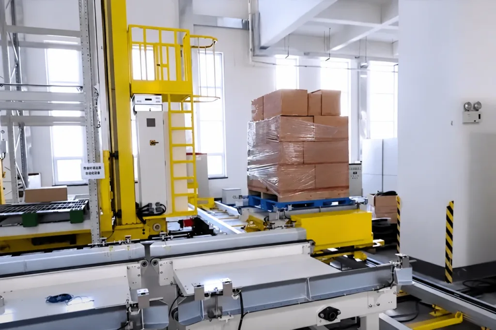 Pallet on a rail-guided conveyor vehicle beside fixed warehouse handling equipment