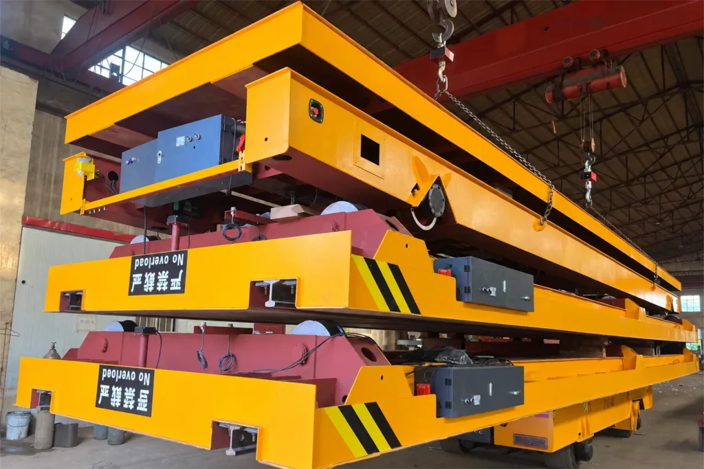 Trackless vehicle assemblies with exposed wheels, electrical enclosures and frames in a supplier workshop