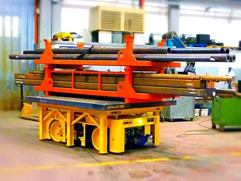 Low industrial cart beneath a separate load support carrying long tubes