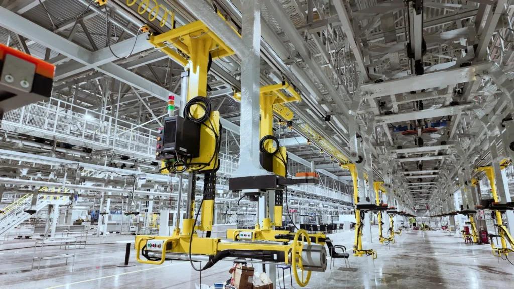 Suspended handling manipulators serving workstations along a factory assembly line