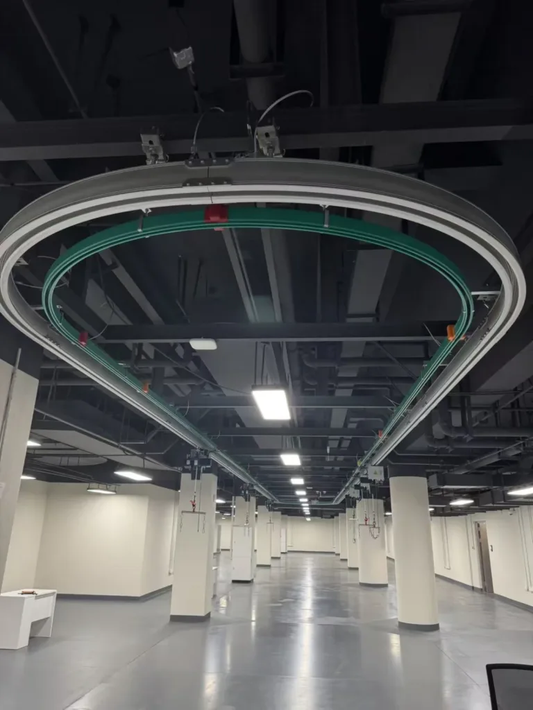 Ceiling-suspended aluminium loop track with a separate conductor system in a test hall