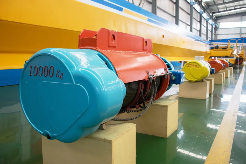 Standard electric wire-rope hoists prepared on a factory test floor with capacity markings visible