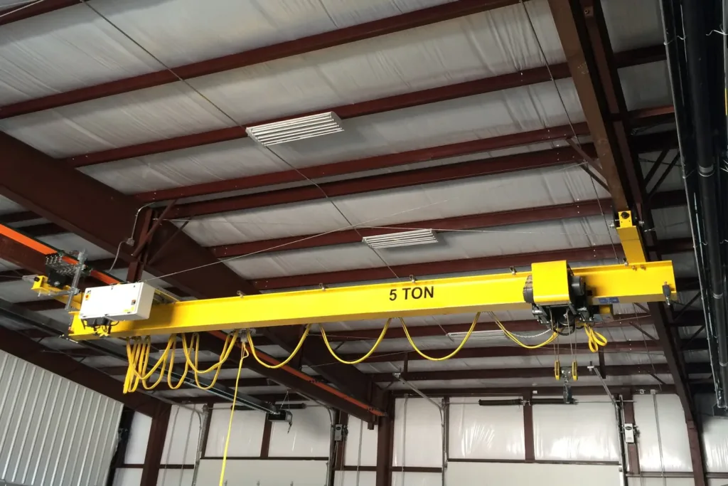 Under-running overhead crane suspended beneath roof-supported runway beams